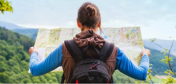 A woman hiking looking at a map. 